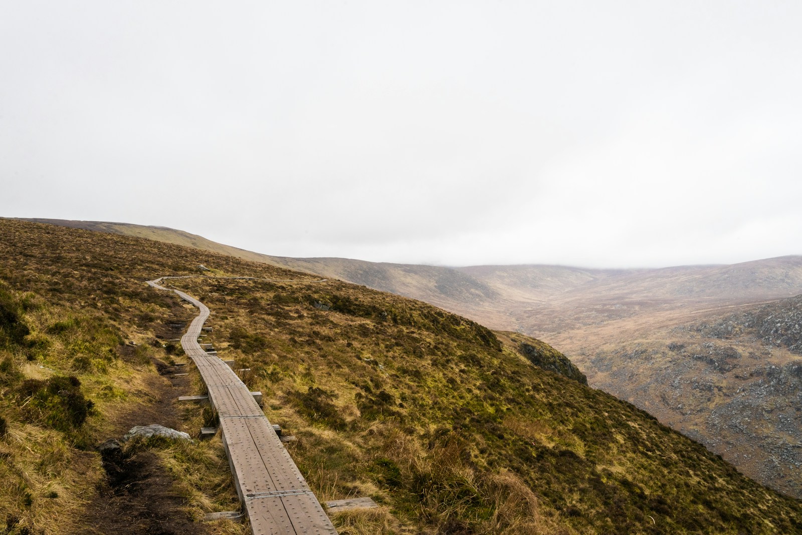 a wooden path on the side of a mountain